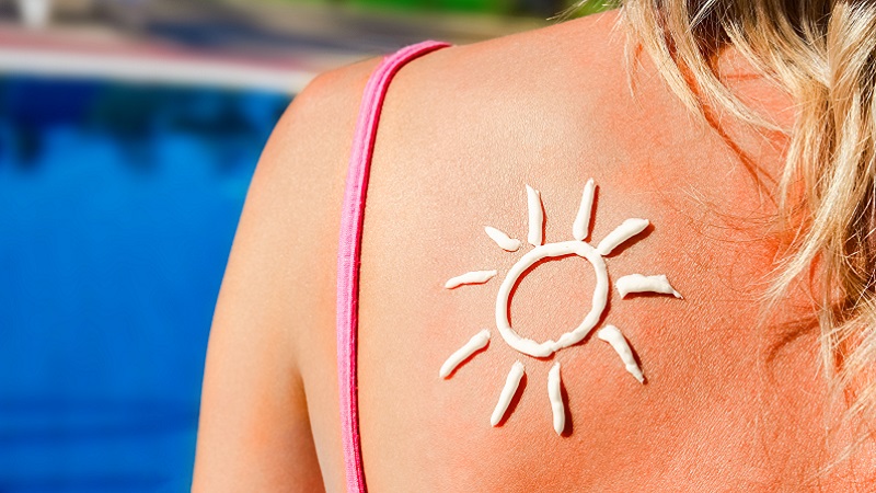 happy girl with the sun on her back at the pool in the nature