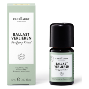 Flasche mit ätherischen Ölen in dunklem Glas, umgeben von einer hellgrünen Verpackung mit Aufschrift "Ballast verlieren".