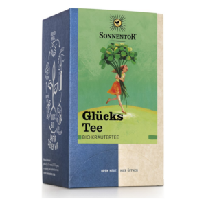 Verpackung von Glücks Tee, einem Bio-Kräutertee, mit einem Mädchen, das frische Kräuter trägt.