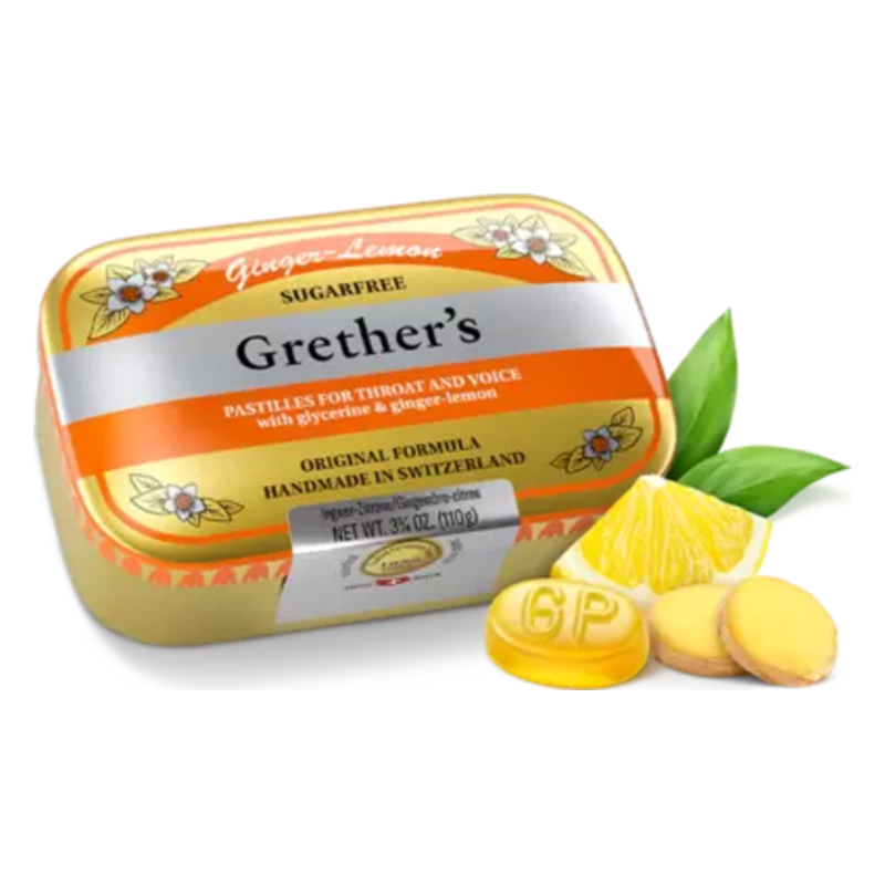 Dose mit Grether’s pastillen in Zitrone-Ingwer Geschmacksrichtung, mit frischen Ingwer- und Zitronenscheiben daneben.